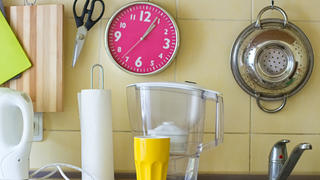 Kitchen table with water filter, clock, paper napkins