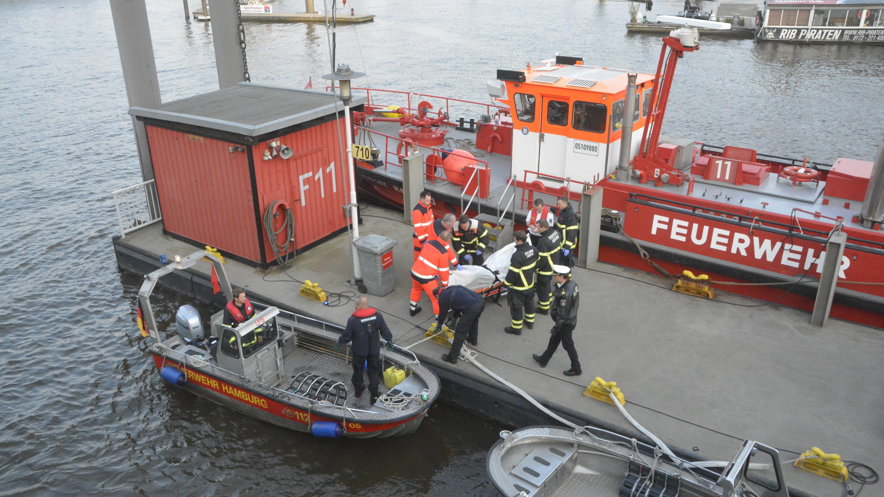 23.04.2018, Hamburg: Eine Leiche wird von einem Boot der Feuerwehr Hamburg auf einen Steg im Hafen getragen. Bei der am Montagmorgen aus der Elbe in der Hamburger Hafencity geborgenen Leiche handelt es sich mit hoher Wahrscheinlichkeit um den vermiss