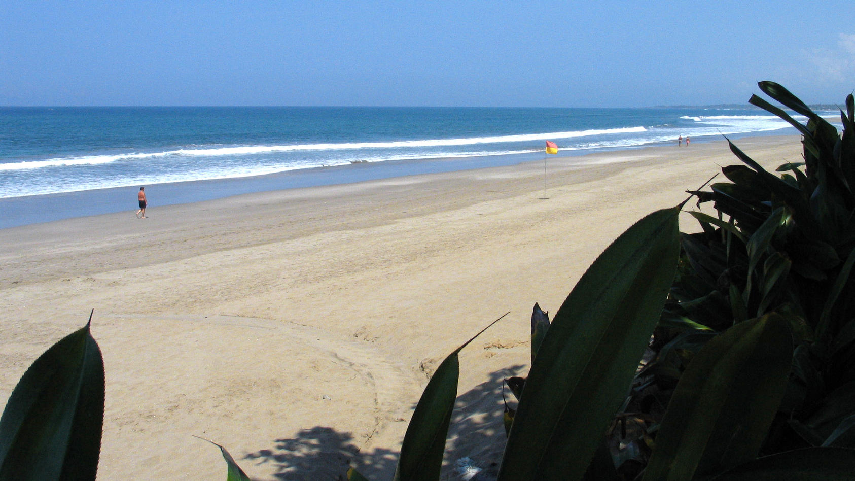 Scheinbar harmlos und verlockend schön - der bei Ebbe besonders breite Sandstrand und die leichte Brandung des Indischen Ozeans im Norden von Kuta (Foto vom 23.11.2004). Bali hat über Jahre viele Idealvorstellungen von einem tropischen Traumurlaub er