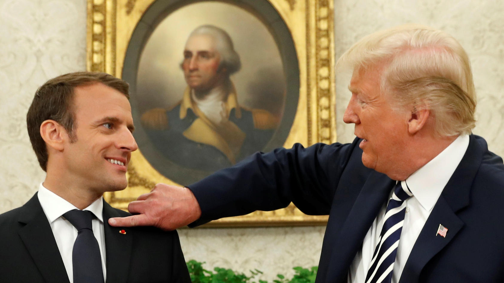 "Du hast da was!", Trump wischt Macron die vermeintlichen Schuppen von der Schulter.
