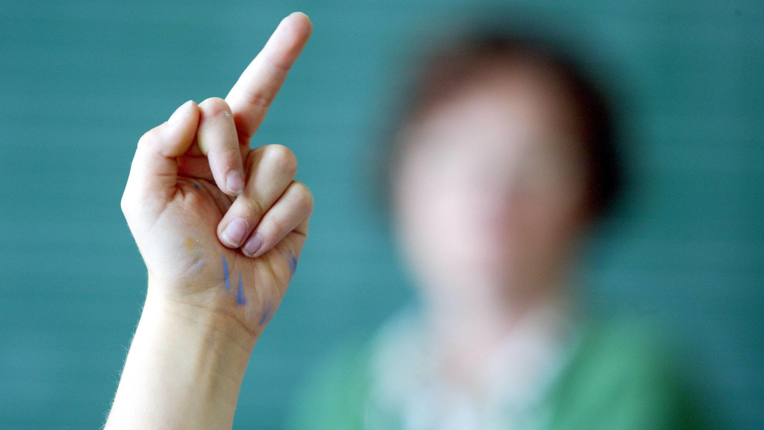 Gewalt gegen Lehrer: Schule . Schülerin zeigt den Mittelfinger