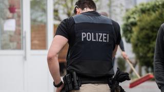 Ein SEK-Beamter steht im Zugang zu einem Grundstück