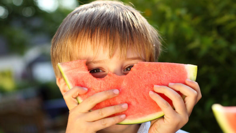 4 jähriger junge blickt durch melone
