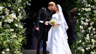 Britain's Prince Harry, Duke of Sussex kisses his wife Meghan, Duchess of Sussex as they leave from the West Door of St George's Chapel, Windsor Castle, in Windsor, Britain, May 19, 2018. Ben STANSALL/Pool via REUTERS