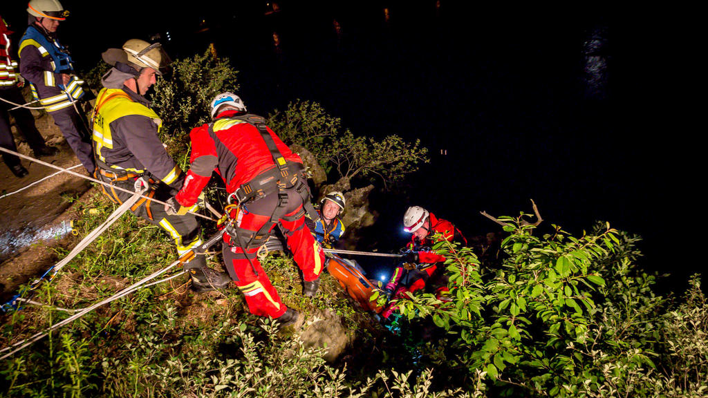 21.05.2018, Rheinland-Pfalz, Sankt Goarshausen: Rettungskräfte und Einsatzkräfte der Feuerwehr bergen einen Mann aus einer Feldwand. Ein 31-Jähriger hat sich bei einem 15 bis 20 Meter tiefen Sturz vom Loreleyfelsen einen Schulterbruch und etliche Pre