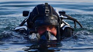 Ein Polizeitaucher schwimmt im Wasser