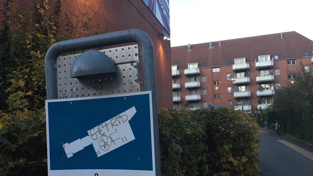 Ein Schild weist am 13.11.2017 im Wohnviertel Mjølnerparken in Kopenhagen (Dänemark) auf Videoüberwachung hin. Das Viertel ist seit Monaten Schauplatz von Bandenschießereien. (zu dpa «Straßenkampf im Szeneviertel - Kopenhagen mit Gangs überfordert» v