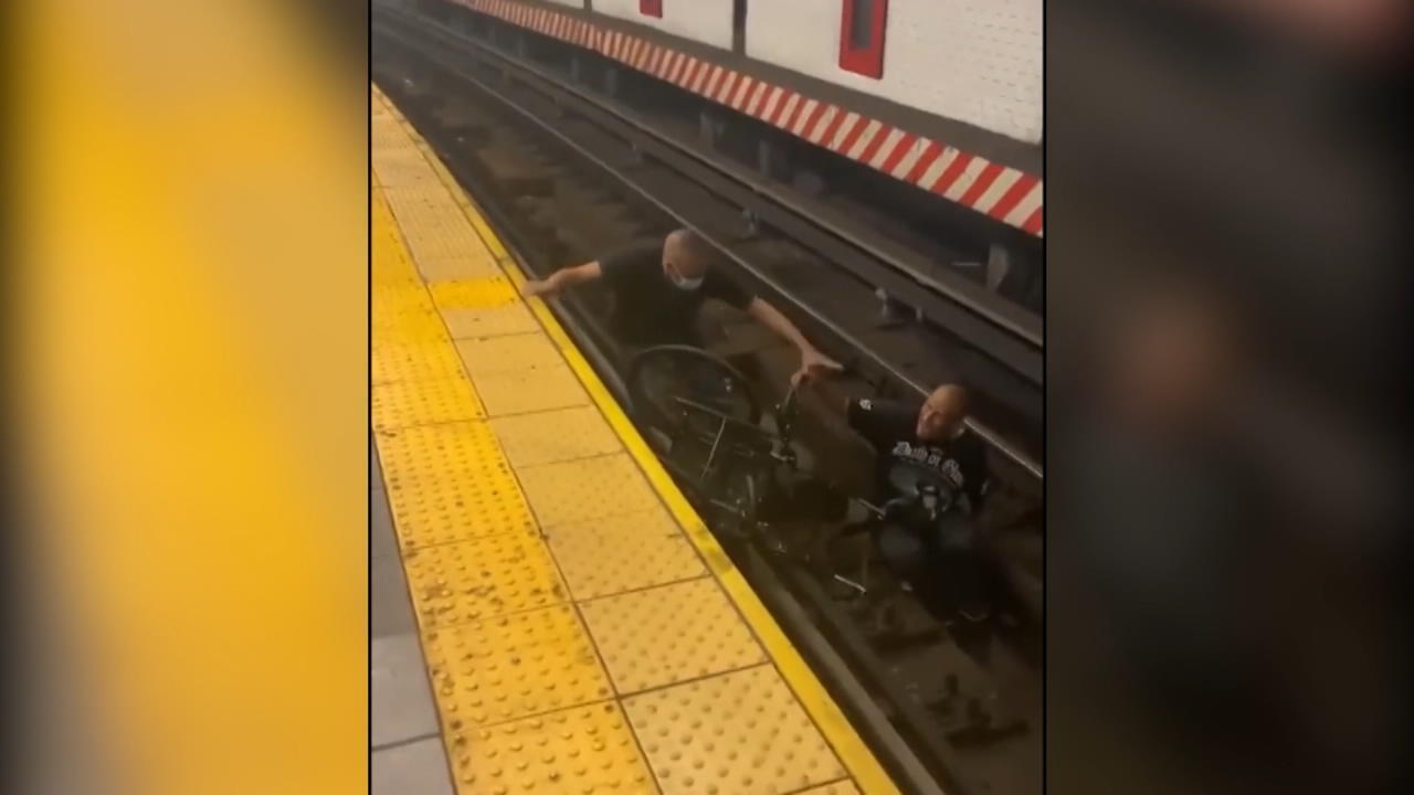 Seorang pengguna kursi roda berbaring di tempat tidur lintasan stasiun kereta bawah tanah, penyelamat heroik tidak ragu-ragu