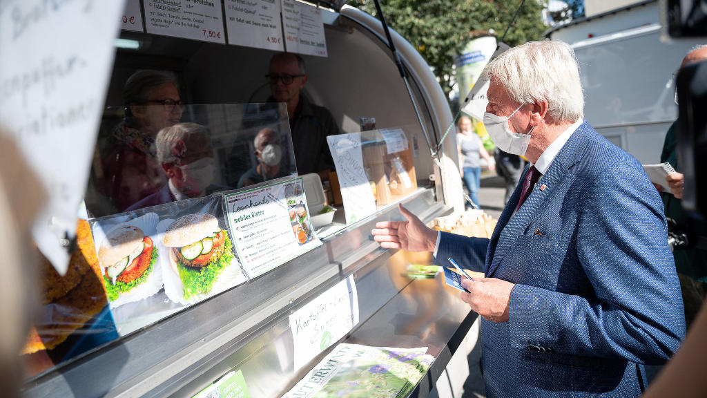 Bouffier wirbt auf dem Wochenmarkt für die Corona-Impfung Pieks zwischen Obstständen in Gießen