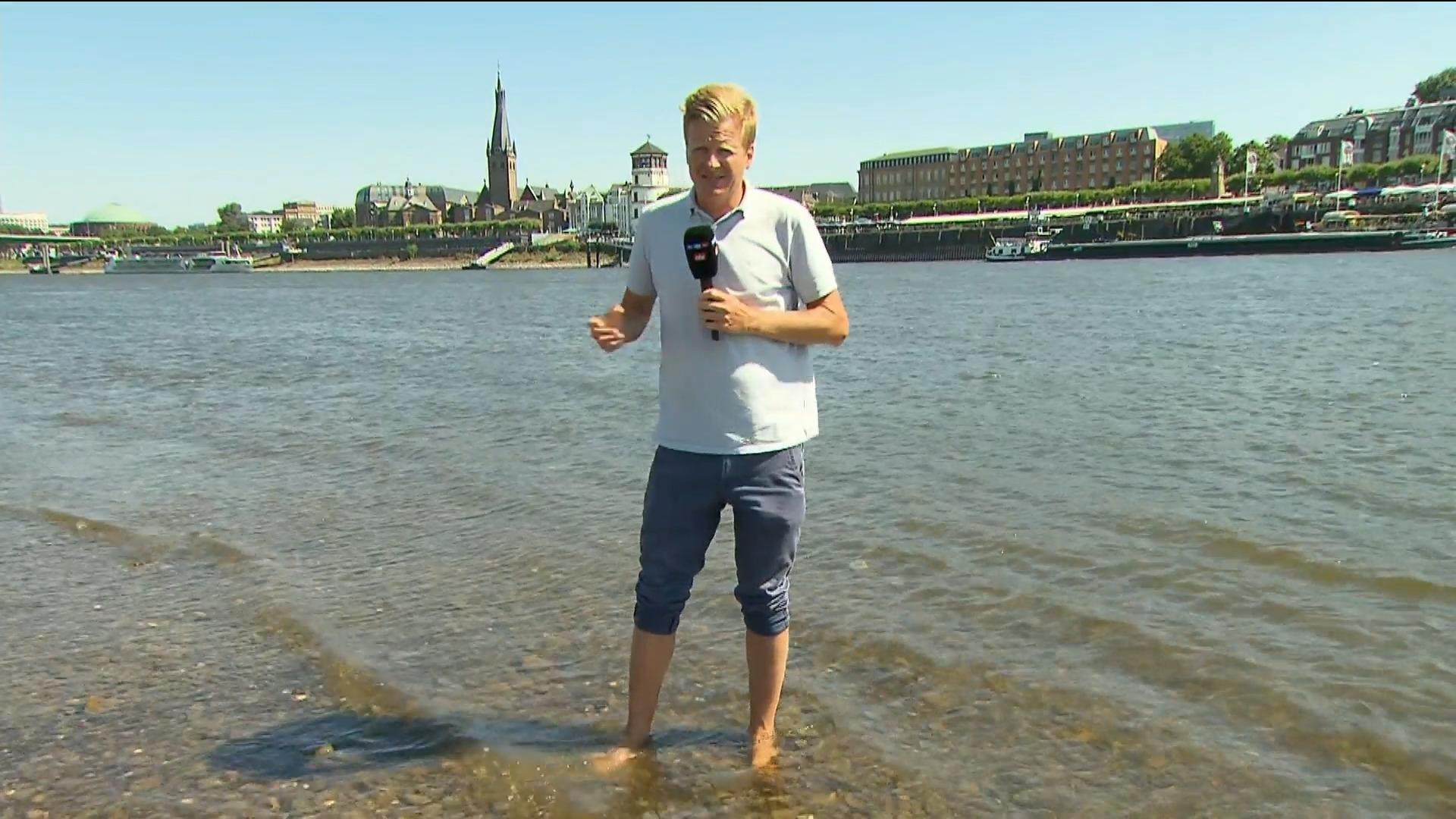RTL-Reporter steht in Düsseldorf mitten im Rhein Niedrigwasser