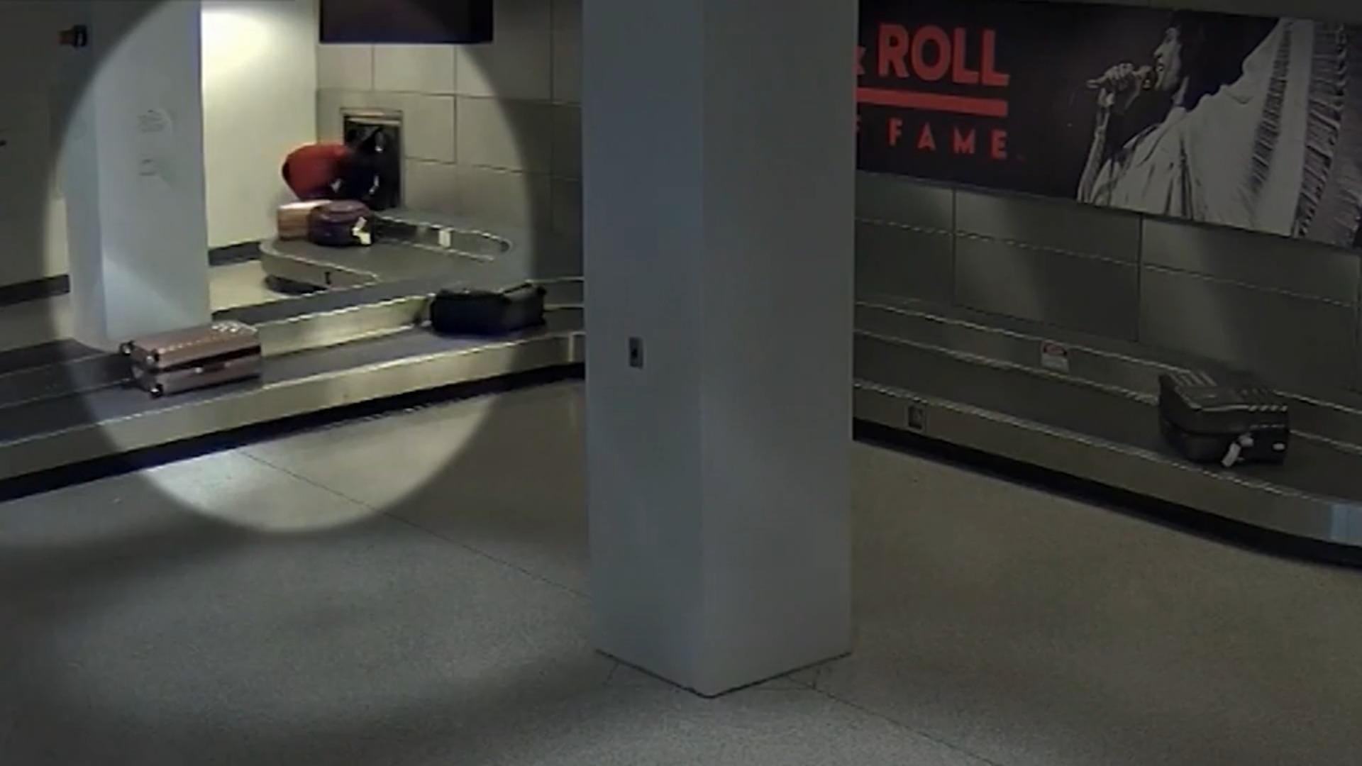 Mann klettert hinter das Gepäckband am Flughafen Weil er seine Schuhe suchte