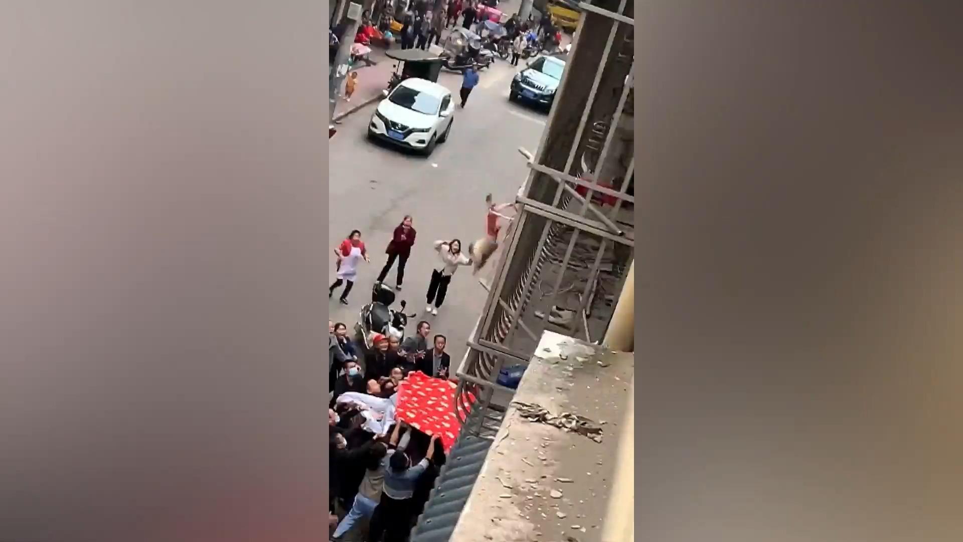 Passanten fangen fallendes Kind mit Decke auf Unglaubliche Rettung in China