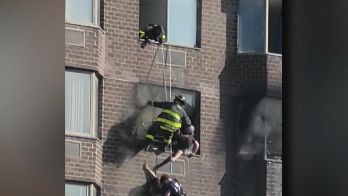 Frau hängt aus brennendem Gebäude Brand wegen E-Bike