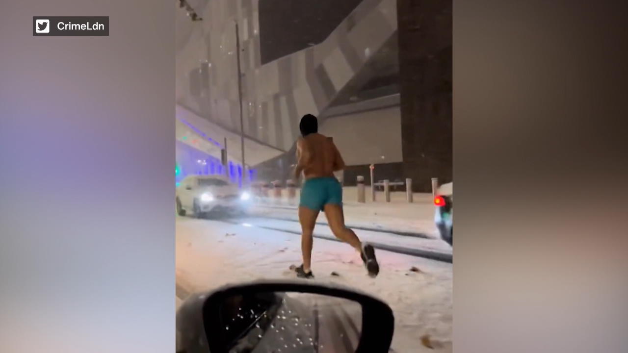 Un uomo corre mezzo nudo nel freddo gelido in un tocco di turchese attraverso la neve
