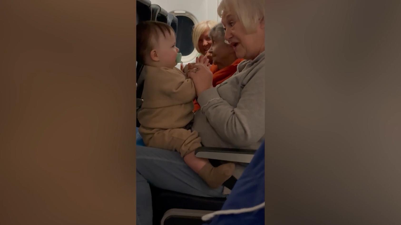 Senioren-Trio beruhigt schreiendes Kind im Flieger Lass das mal die Omis machen!