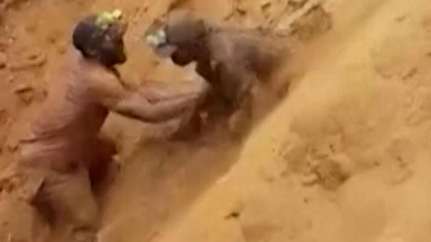 I soccorritori estraggono i sopravvissuti da una miniera sepolta a mani nude