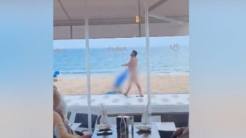 Seorang pria berjalan telanjang di sepanjang hotspot turis membiarkan semuanya nongkrong!