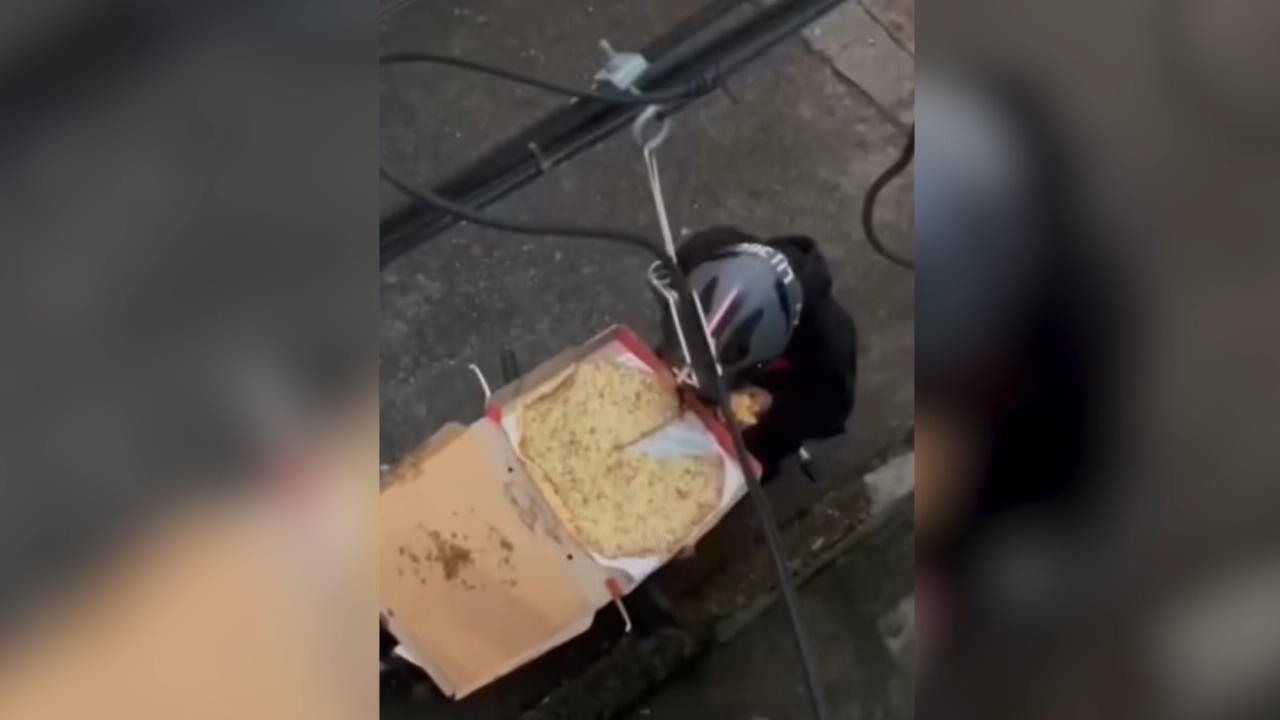 Caught in the act: Rude delivery guy steals a slice of pizza.