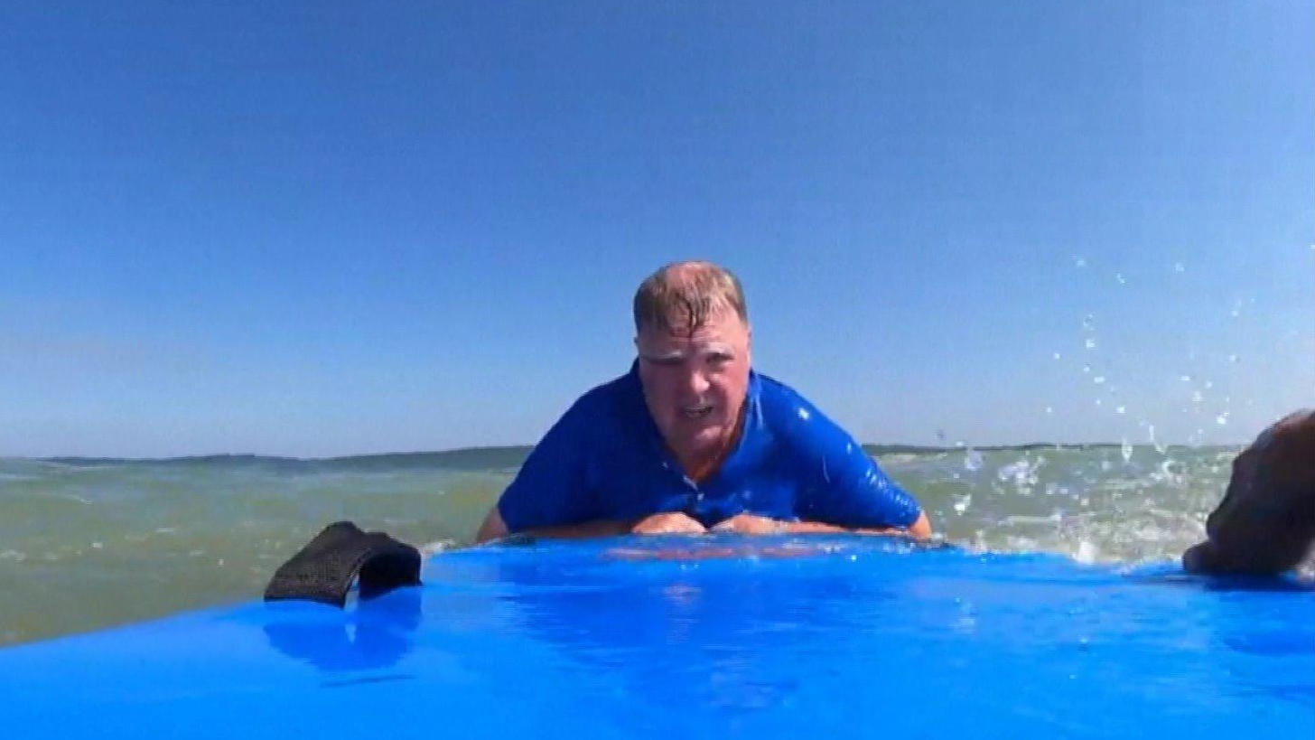 L'onda lo ha colpito!  Un surfista salva un uomo che sta annegando. Un aiutante osserva la lotta per sopravvivere nell'acqua