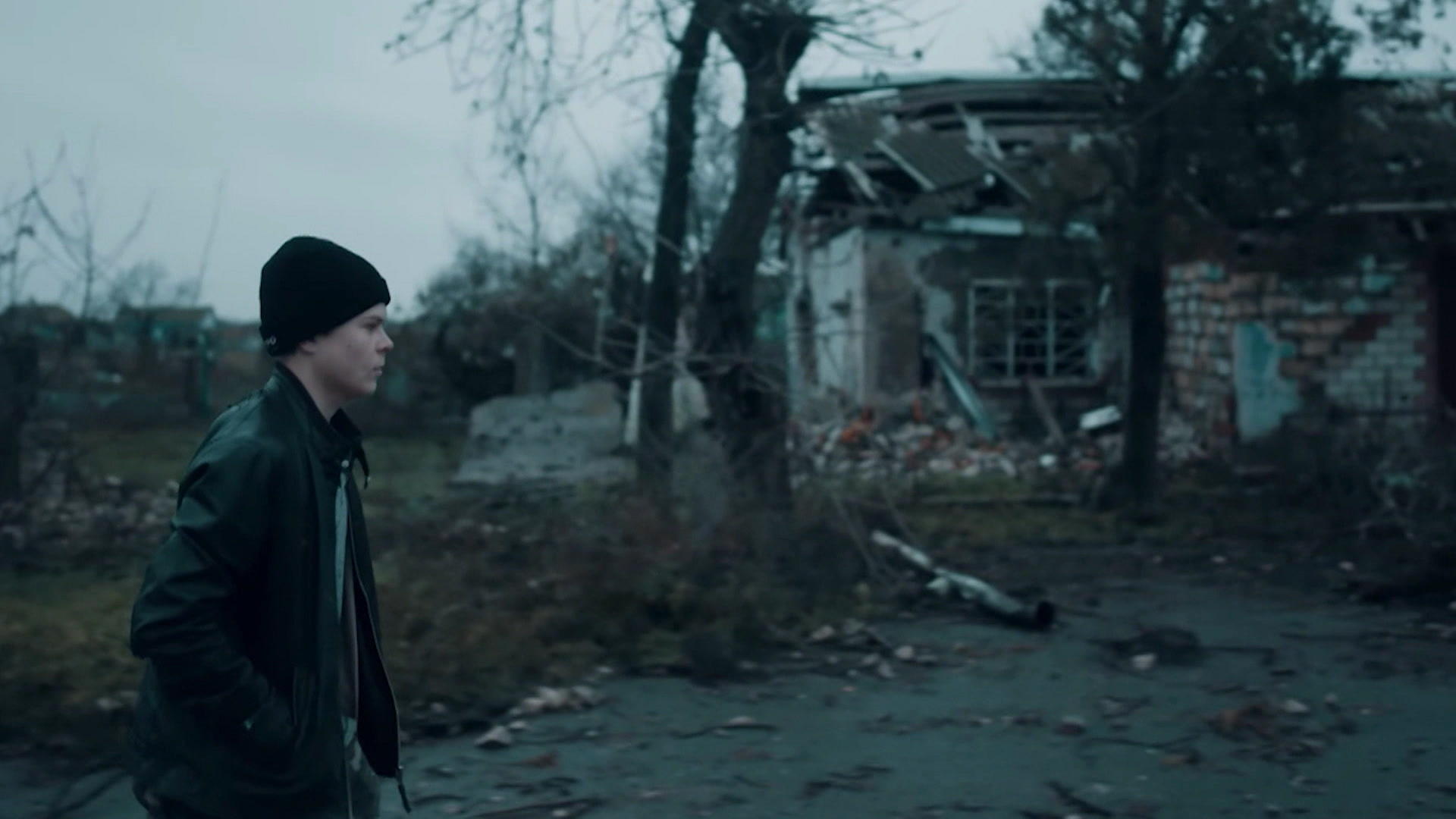 Ukraine: Sasha (14 years old) stands in front of the ruins of his village, and the band gives him new hope